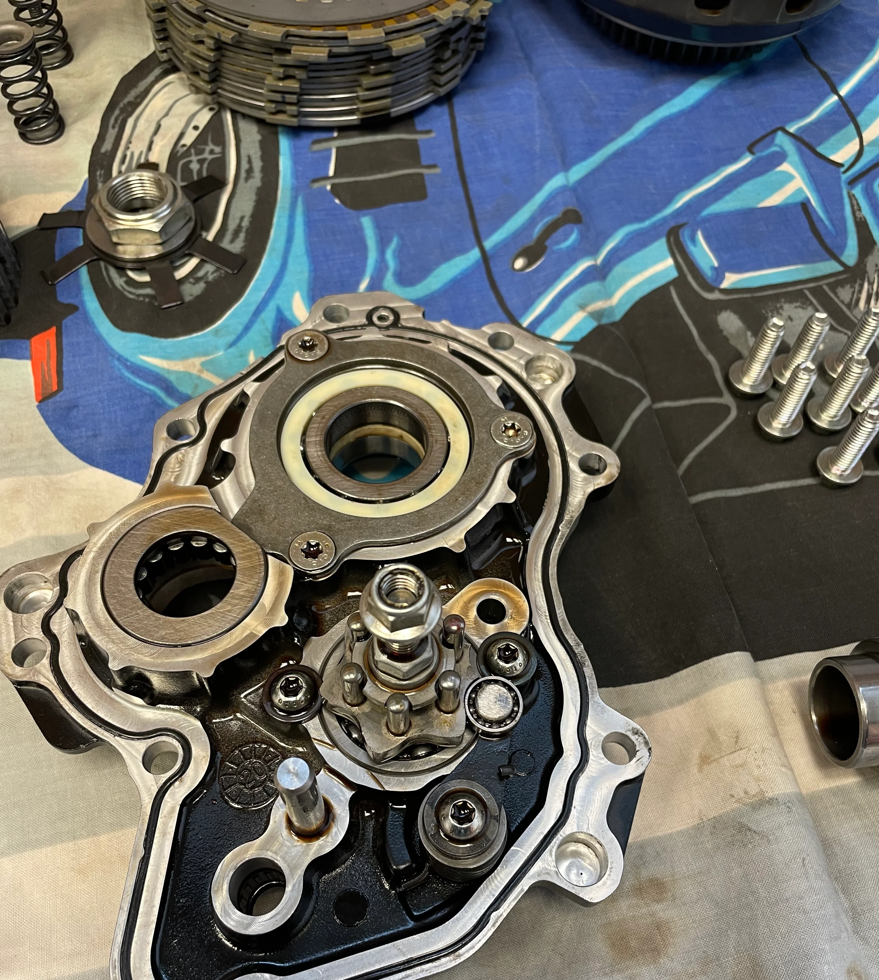 Detailaufnahme eines Motordeckels mit Lagern und Schrauben auf der Werkbank