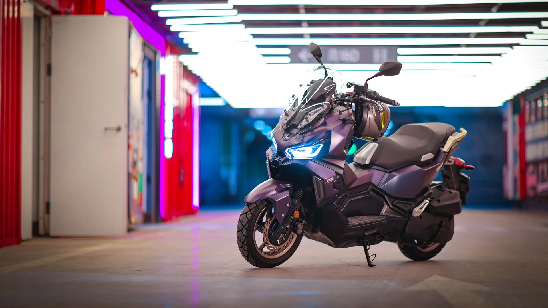 Violetter SYM Maxi-Roller inszeniert in einer beleuchteten Garage